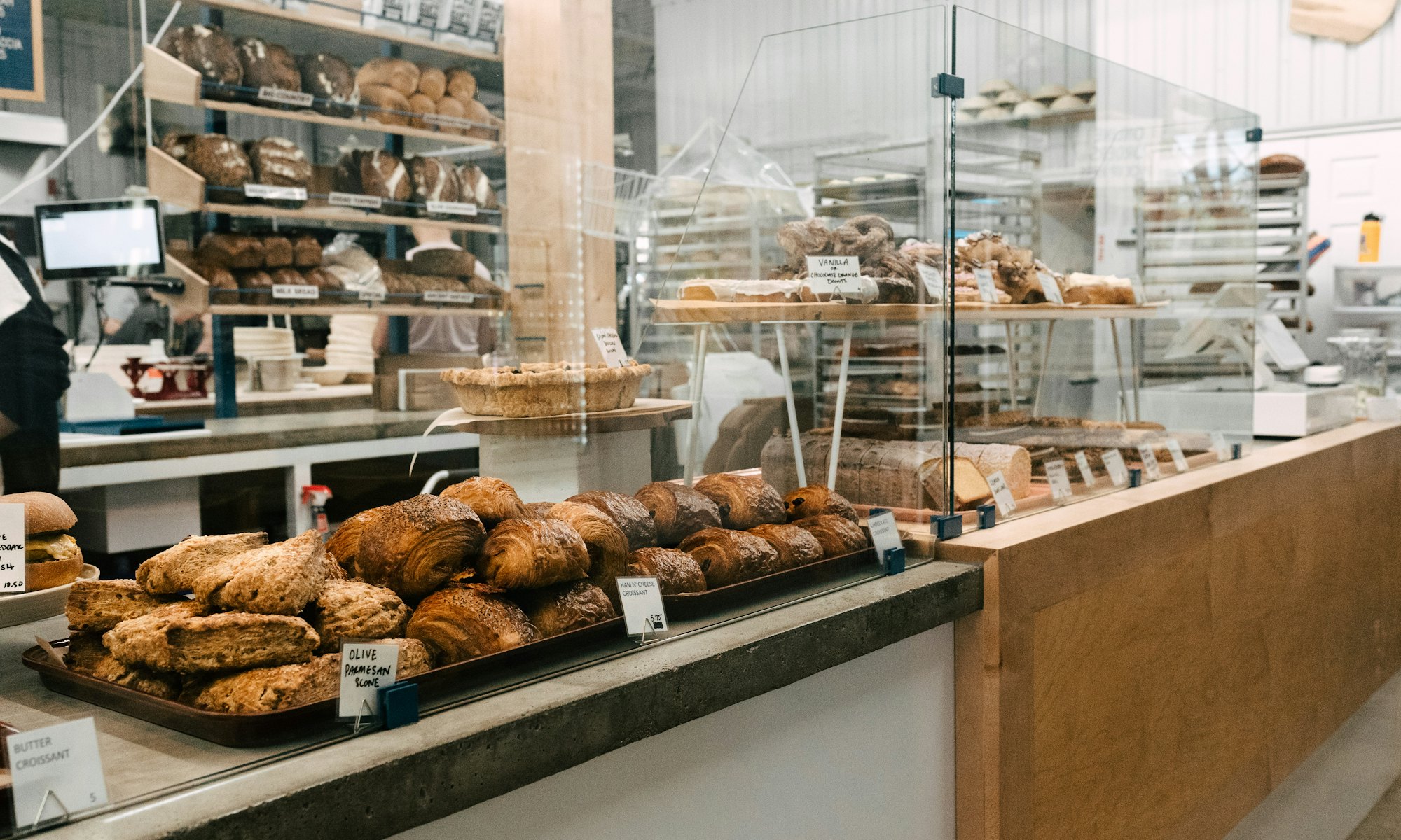 Disken i bageriet med croissanter, bullar och bröd i hyllorna bakom