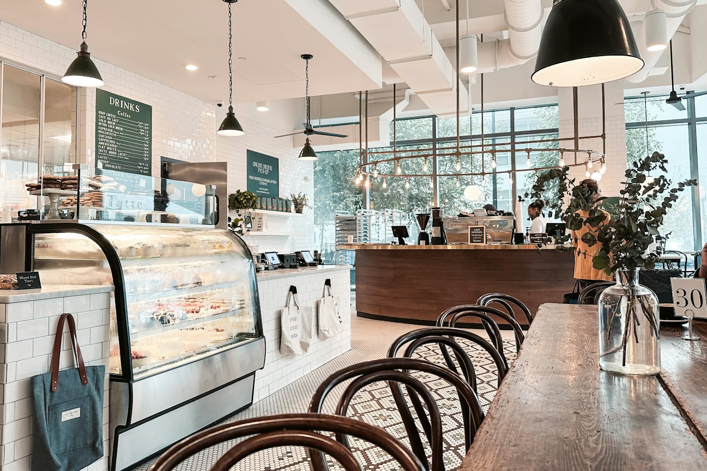 Kaféet inifrån med långbord, stolar och disken i bakgrunden